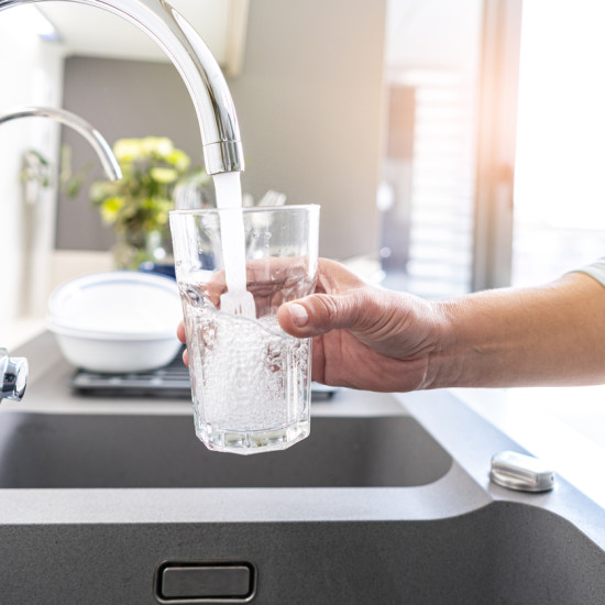 Une personne qui se sert de l'eau potable