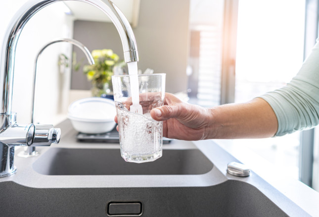 Une personne qui se sert de l'eau potable